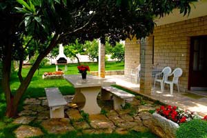 Kameni stol i kamin u prostranom dvorištu apartmana Marko